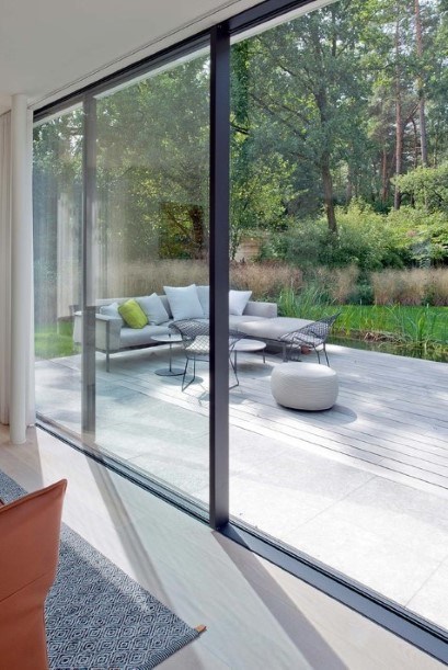grote ramen met zwarte aluminium profielen met zicht op terras en tuin