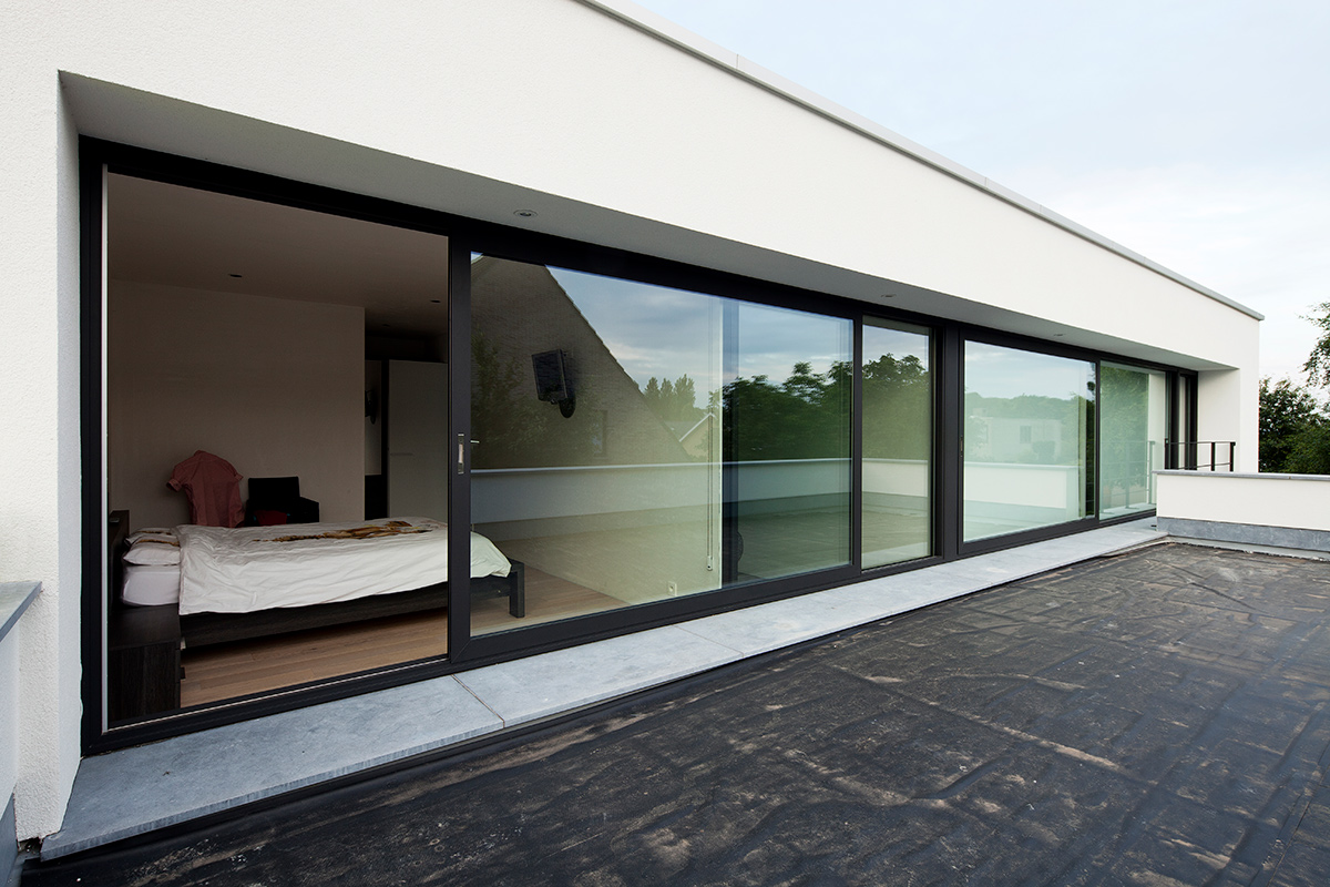 maison moderne avec de grandes fenêtres avec des profilés en aluminium noir avec vue sur la terrasse sur le toit