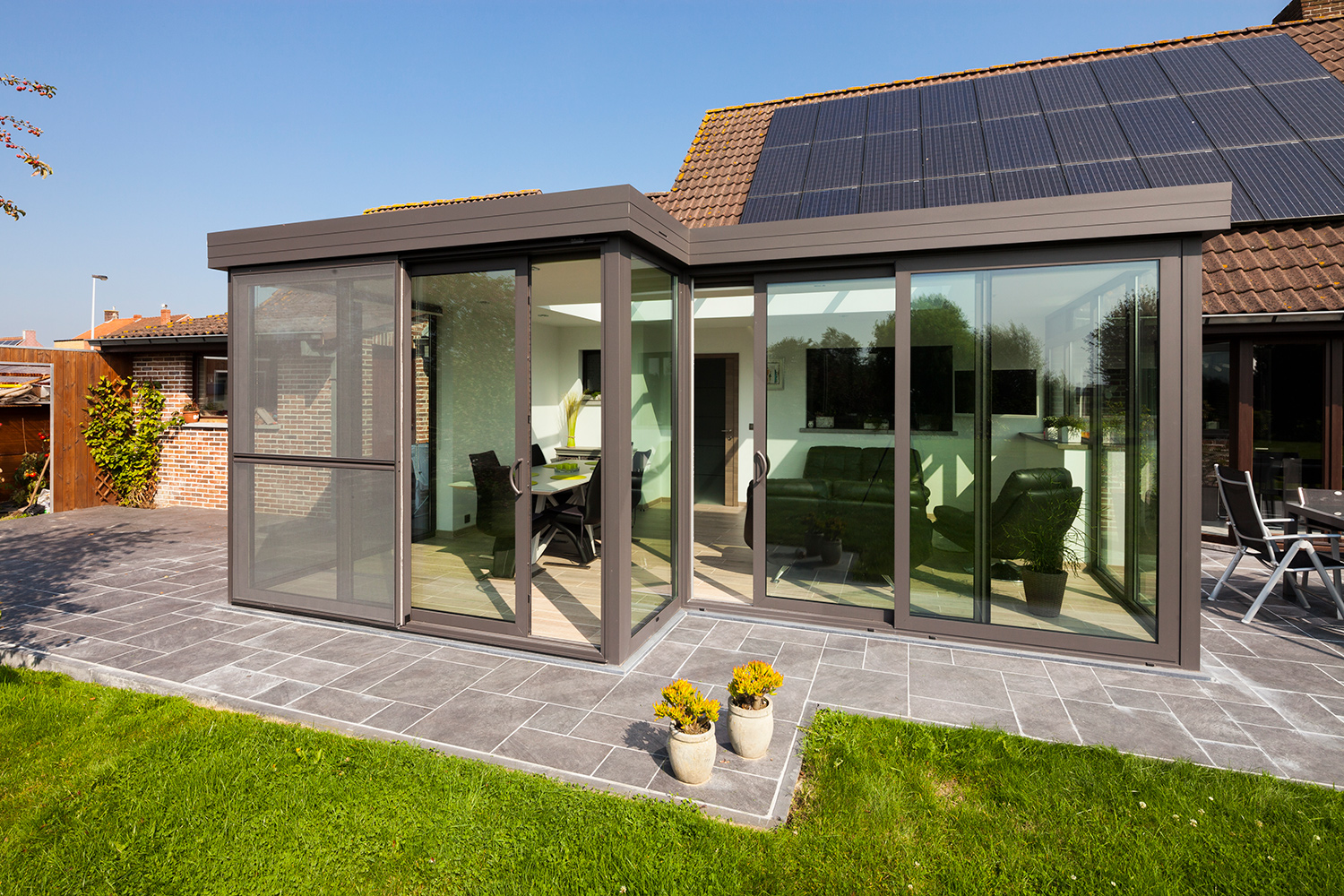 grijze aluminium veranda met grote aluminium ramen met grijze profielen