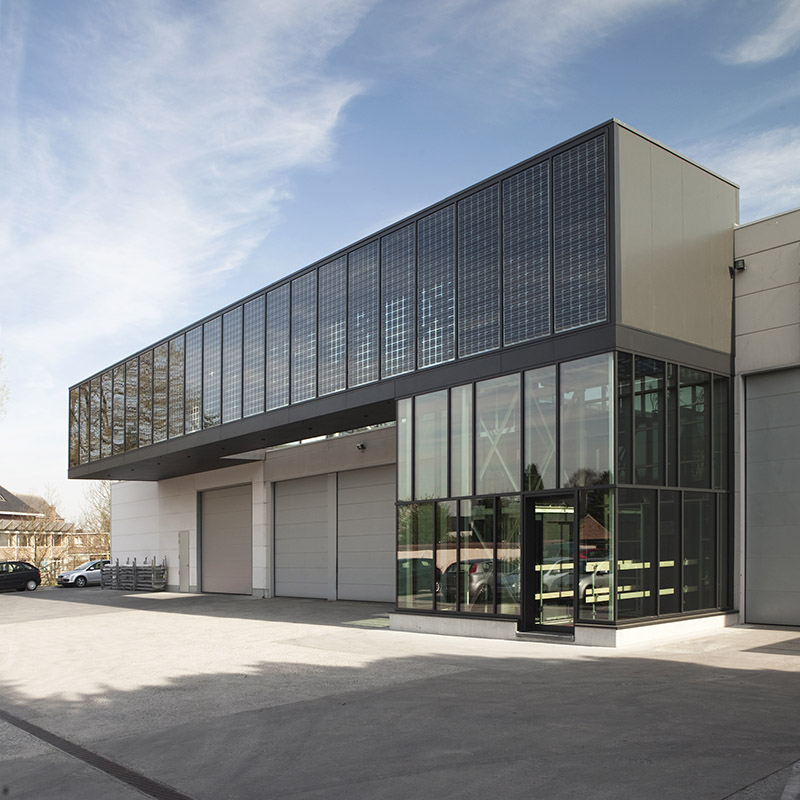 Modern industrieel gebouw met gevel bestaande uit grote glaspartijen met zwarte aluminium profielen