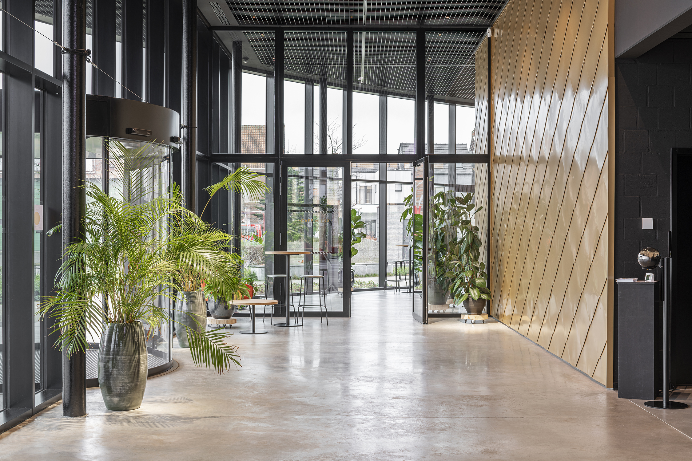lux zaal met grote ramen met zwarte aluminium profielen die het polyvalente karakter van het gebouw versterken