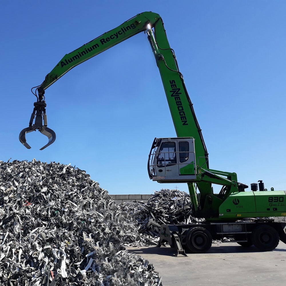 scrap aluminium being gathered by a crane for recycling